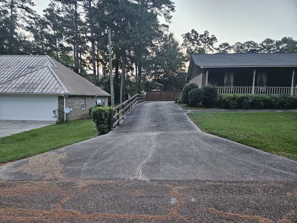 Wide view of outdoor buildup on a Collins driveway before cleaning