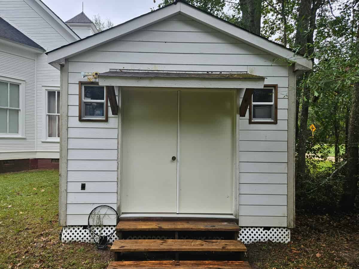 Outbuilding double-door entrance and painted wood siding after cleaning at Harvest Church