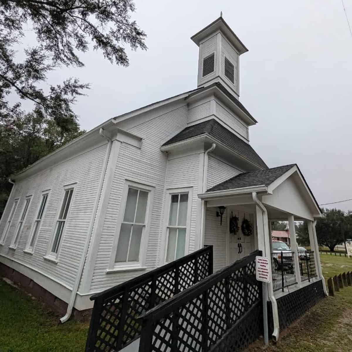 Front entrance, bell tower, and porch of Harvest Church before exterior cleaning in Sanford, Mississippi