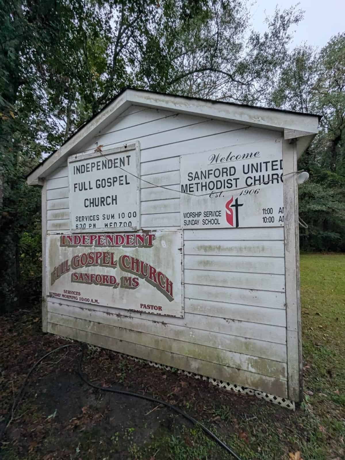 Organic buildup on the painted wall around existing church signs before cleaning in Sanford