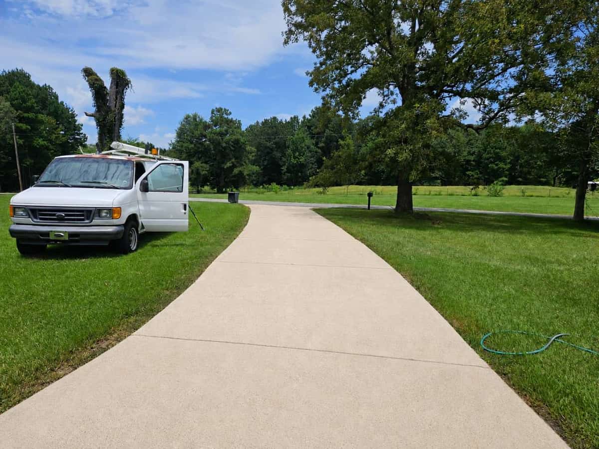 Residential concrete driveway after cleaning in Magee, Mississippi, viewed from the opposite direction